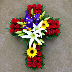 Cross-shaped floral arrangement with red roses, white lilies, and yellow daisies