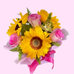 Bouquet of yellow sunflowers and pink roses with a pink ribbon