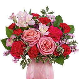 Pink roses and red carnations in a pink glass vase