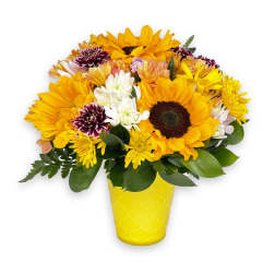 Mixed yellow and white flowers in a yellow vase