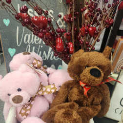Plush teddy bears in a wooden crate with red berry stems