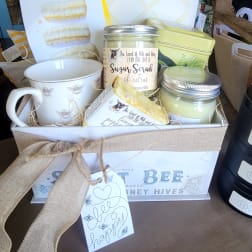 Gift basket with mug, candles, and bath items tied with a burlap ribbon