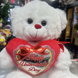 White teddy bear holding a red heart that says Happy Valentine's Day