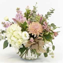 Mixed pastel bouquet in a clear glass vase with a burlap bow