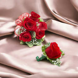Red rose bouquet and matching boutonniere on satin fabric