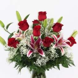 Red roses and pink lilies arranged in a glass vase