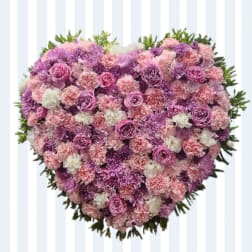 Heart-shaped floral arrangement in pink, purple, and white flowers