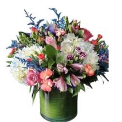 Mixed bouquet of pink, white, and purple flowers in a green glass vase