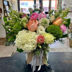 Mixed bouquet in a white hatbox with pink, peach, and white blooms