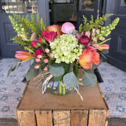 Colorful bouquet in a glass vase with roses, hydrangea, and tulips