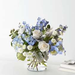 Blue and white flower arrangement in a clear glass vase