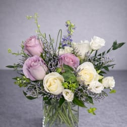 Bouquet of lavender and white roses in a clear glass vase