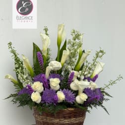 Basket arrangement of white calla lilies, roses, and purple flowers