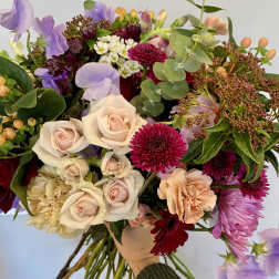 Mixed bouquet with pale roses, purple sweet peas, and magenta blooms