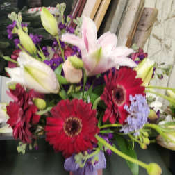 Bouquet of lilies and red gerbera daisies in a small vase