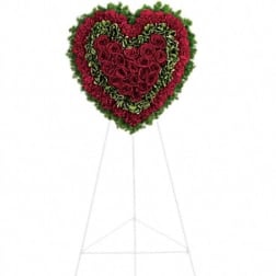 Heart-shaped standing floral tribute with red roses and carnations on an easel