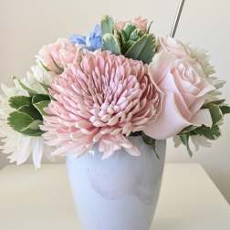 Pastel arrangement of pink chrysanthemum, rose, and white flowers in a light blue vase