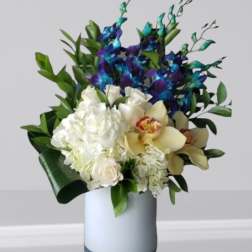 White and blue floral arrangement in a light vase