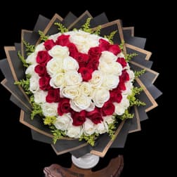 Heart-shaped bouquet of red and white roses in black wrap