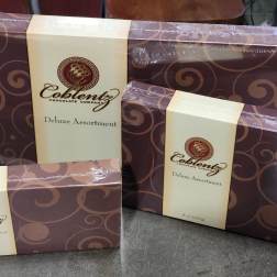Three boxed assortments of chocolates with brown and cream packaging
