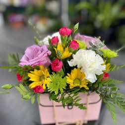 Mixed bouquet in a pink gift box with roses, carnations, and daisies
