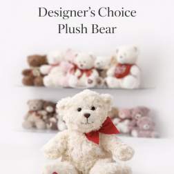 Cream plush teddy bear with red bow and heart on paw, with other teddy bears blurred in the background