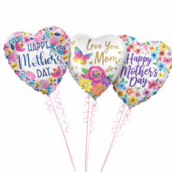 Three heart-shaped Mother's Day balloons with floral prints and pink ribbons