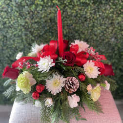 Holiday centerpiece with red candle, roses, and white flowers