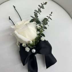 White rose boutonniere with black ribbon and pearl accent