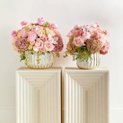 Two pink floral arrangements in gold wire vases on pedestals