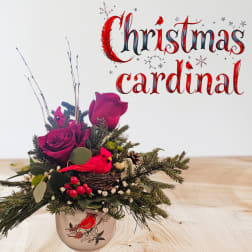 Christmas floral arrangement in a bird-decorated mug with red roses