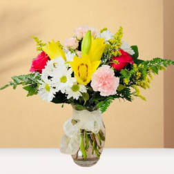 Mixed bouquet with yellow lilies, white daisies, pink roses, and carnations in a glass vase