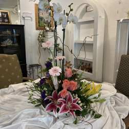 Tall floral arrangement with orchids, lilies, roses, and gerbera daisies