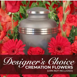 Cremation urn surrounded by red flowers and greenery