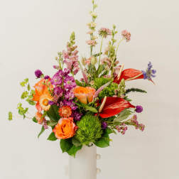 Colorful mixed bouquet in a tall white vase