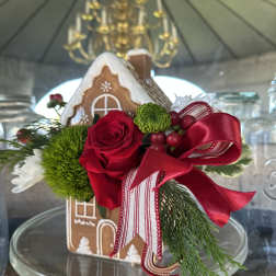 Gingerbread house decorated with a red rose and ribbon
