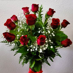 Bouquet of red roses with baby's breath in a glass vase