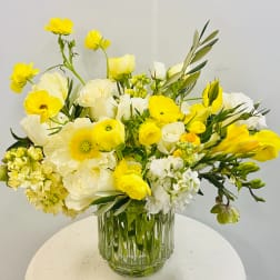 Yellow and white mixed bouquet in a clear glass vase