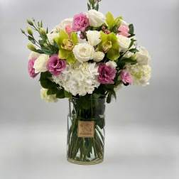 Bouquet of white, pink, and green flowers in a clear glass vase