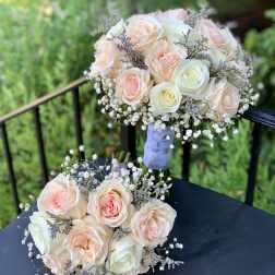 Two pastel rose bouquets with baby's breath on a dark table