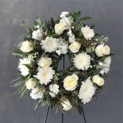 White rose and chrysanthemum wreath on a black stand
