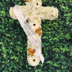 White floral cross with a memorial ribbon and orange butterflies