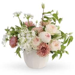 Pink and white floral arrangement in a white ceramic vase