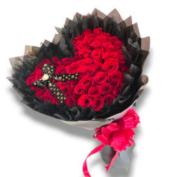 Bouquet of red roses wrapped in black paper with a pink ribbon