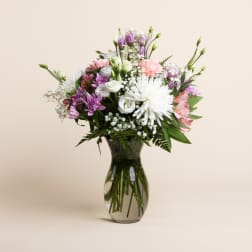 Mixed pink, white, and purple bouquet in a glass vase