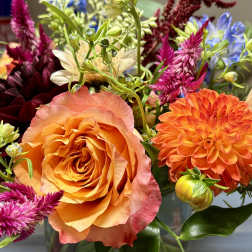 Colorful mixed bouquet in a glass vase with orange and pink blooms
