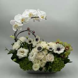 White orchids and roses arranged in a low rectangular container