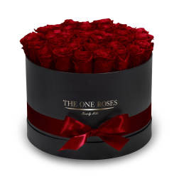 Round box filled with red roses and tied with a red ribbon