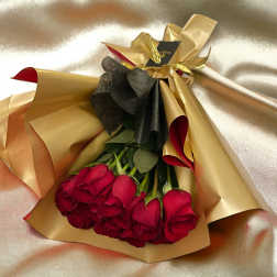 Bouquet of red roses wrapped in gold and black paper
