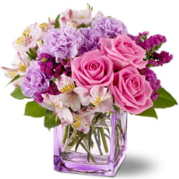 Pink and lavender bouquet in a square glass vase